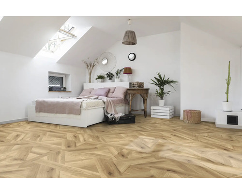 Schlafzimmer mit Dachfenster, Bett und Holzboden im Fischgrätmuster