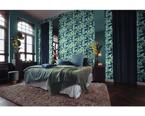 Schlafzimmer mit Bett, Nachttisch, Tapete mit Pflanzenmuster und Teppich