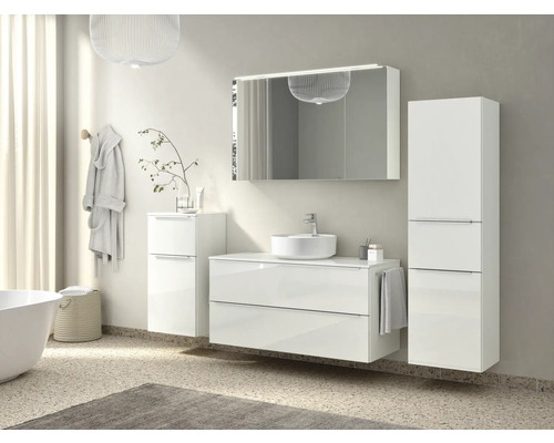 Helles Badezimmer mit Waschtisch, Spiegel, Spiegelschrank und Hochschrank für Badezimmerutensilien.