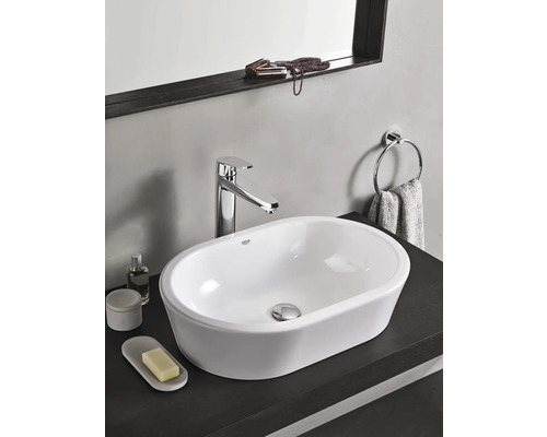 Modernes Badezimmerwaschbecken mit Armatur, Handtuchhalter und Accessoires auf dunkler Oberfläche