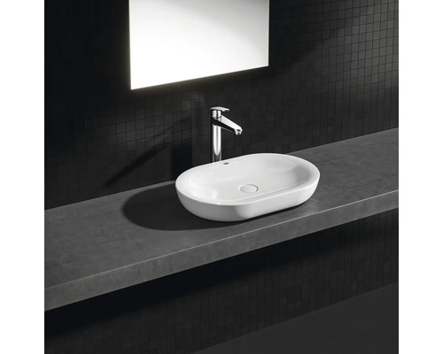 Aufsatzwaschbecken aus Keramik mit Armatur auf einer Ablage im Badezimmer.