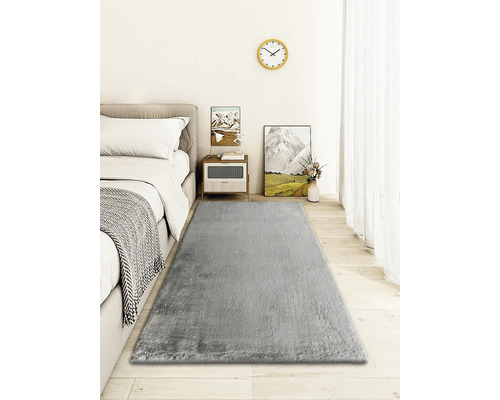 Helles Schlafzimmer mit Bett, Nachttisch und grauem Teppich
