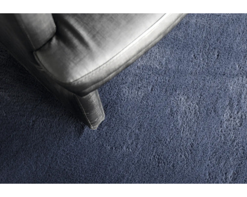 Detailaufnahme eines Textilteppichs neben einem Möbelstück