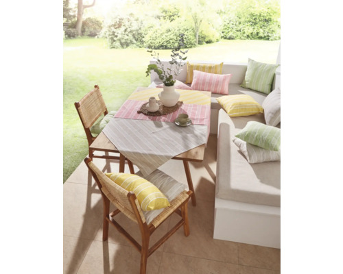 Terrasse mit Holztisch, Stühlen und farbigen Kissen für eine gemütliche Atmosphäre im Freien