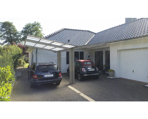 Carport aus Metall mit zwei Autos vor einem Wohnhaus