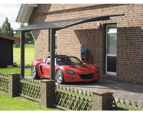 Auto unter Carport vor einem Backsteinhaus