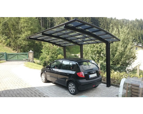 Carport mit Auto auf einem gepflasterten Hof