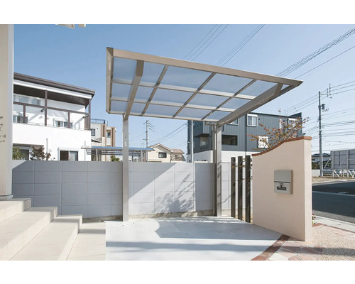 Carport aus Metall mit transparentem Dach und Betonmauer