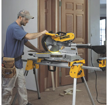 Ein Mann bedient eine DeWalt Kappsäge auf einem Arbeitstisch in einem Raum.