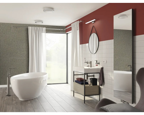 Helles Badezimmer mit Badewanne, Waschtisch, Spiegel und Fenster für ein modernes Ambiente