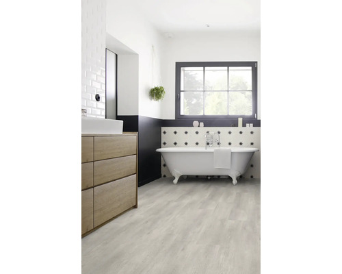 Helles Badezimmer mit freistehender Badewanne, Waschtisch und hellem Holzboden