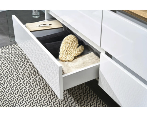 Offene Schublade eines Badezimmerschranks mit Handtüchern und Waschlappen