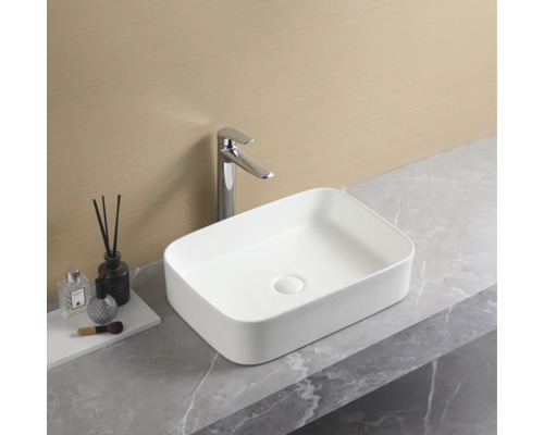 Rechteckiges Aufsatzwaschbecken aus Keramik mit Armatur auf einer Waschtischplatte