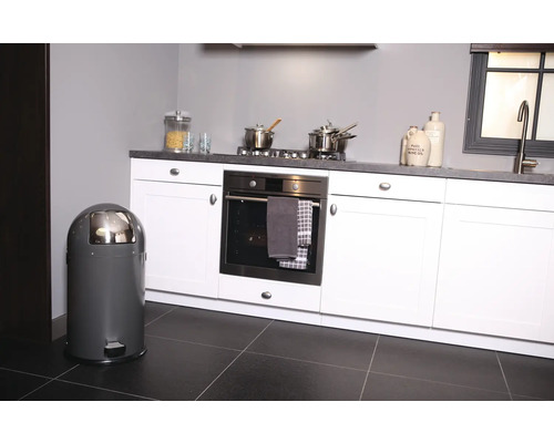 Grauer Treteimer in einer modernen Küche mit weißen Schränken und Geräten