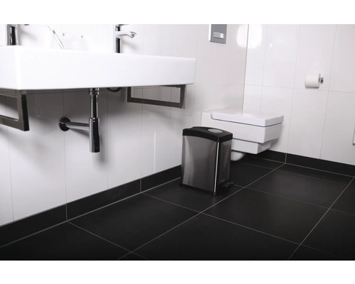 Badezimmer mit Waschbecken, Toilette und Treteimer