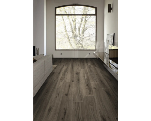 Heller Wohnraum mit Fenster, Sofa und Laminatboden in Holzoptik