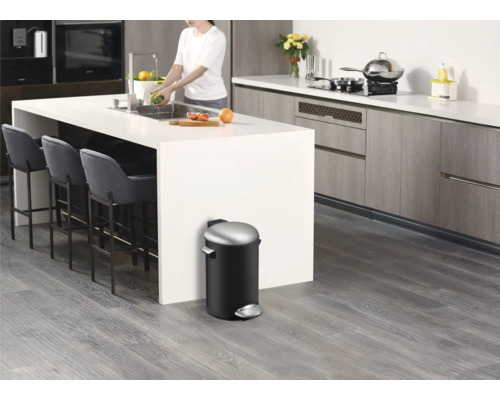 Moderne Küche mit Kücheninsel, Barhockern und einem schwarzen Tretabfalleimer.