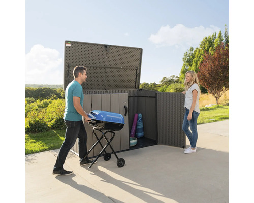 Geräumiger Gartenschrank mit Mann, der Grill hineinstellt, und Frau, die daneben steht