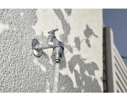 Außenwasserhahn an einer Wand mit fließendem Wasser