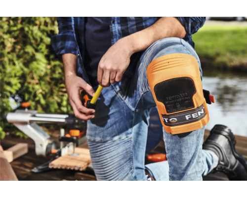 Handwerker mit Knieschonern bei der Arbeit mit einer Stichsäge