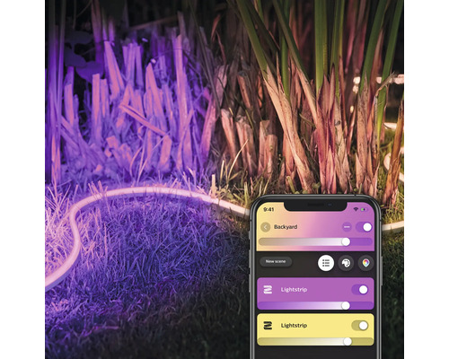 LED-Lichtstreifen beleuchtet einen Garten, gesteuert über eine Smartphone-App.
