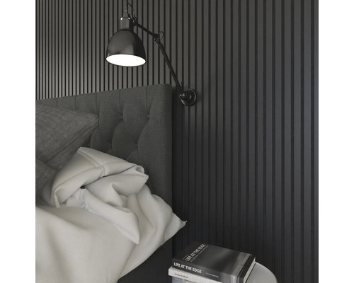 Schlafzimmer mit Wandpaneelen, Bett, Nachttischlampe und Buch