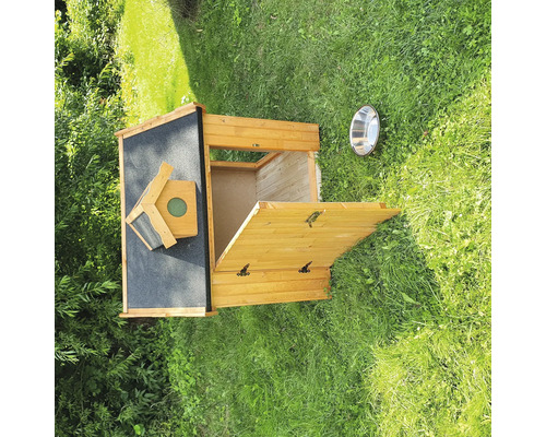 Hundehütte aus Holz mit geöffneter Tür und Futternapf im Garten