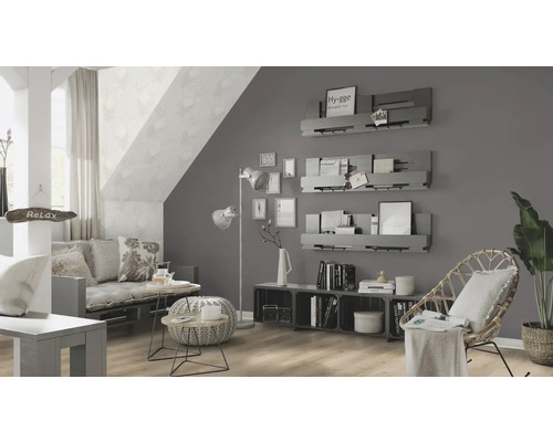 Wohnzimmer mit Sofa, Sessel und Wandregalen unter einer Dachschräge