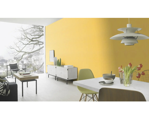 Heller Wohnraum mit gelber Wandfarbe, Esstisch, Sideboard und Fensterfront