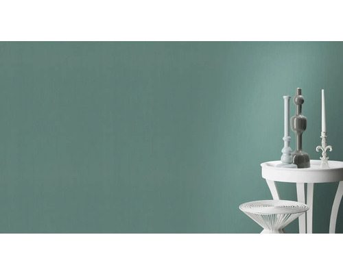 Wandgestaltung mit dekorativen Elementen auf weißen Beistelltischen vor einer einfarbigen Wand