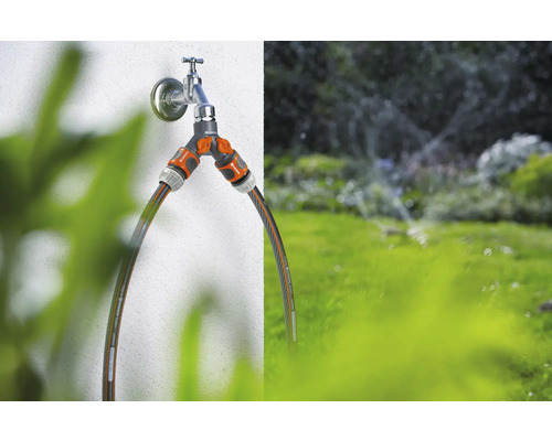 Gartenszene mit Wasserhahn, Verteiler und Gartenschläuchen zur Bewässerung