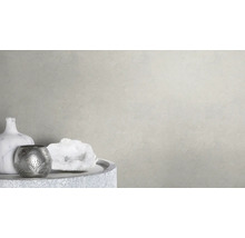 Dekorative Szene mit Vase, Teelichthalter und Schmuckstein auf einem Tisch vor einer hellen Wand