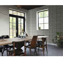 Esszimmer mit Esstisch, Stühlen, Fenster und Wand mit Betonblock-Optik
