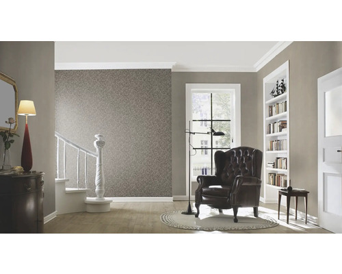 Wohnzimmer mit Tapete, Sessel, Treppe und dekorativen Elementen für ein behagliches Ambiente