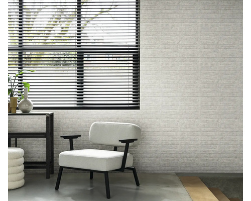 Innenraum mit Fenster, Jalousien, Sessel und einer Wand mit Backsteinmuster