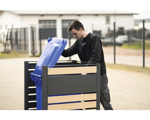 Mülltonnenbox mit einer Person, die eine blaue Mülltonne hineinstellt