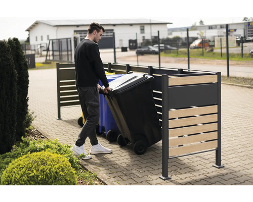 Mülltonnenbox mit Person, die eine Mülltonne hineinstellt