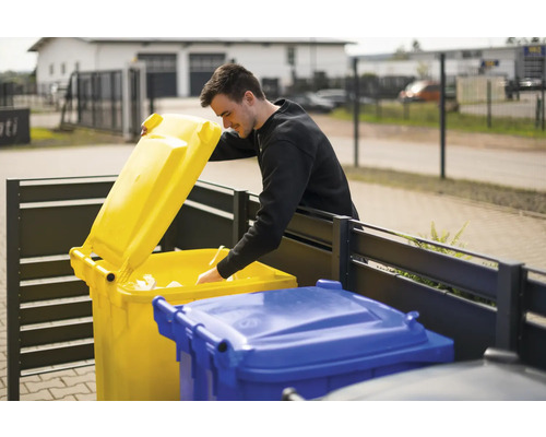 Mann wirft Papier in eine gelbe Mülltonne