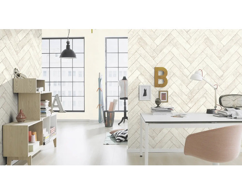 Heller Raum mit Bücherregal und Schreibtisch vor einer Wand mit Fischgrätenmuster-Tapete