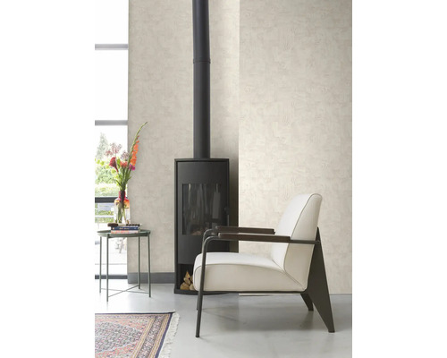 Wohnzimmer mit Ofen, Sessel, Tisch und gemusterter Tapete.