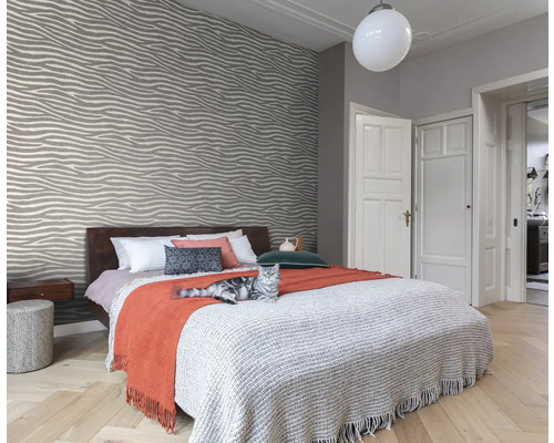 Helles Schlafzimmer mit gemusterter Tapete, Bett und Katze