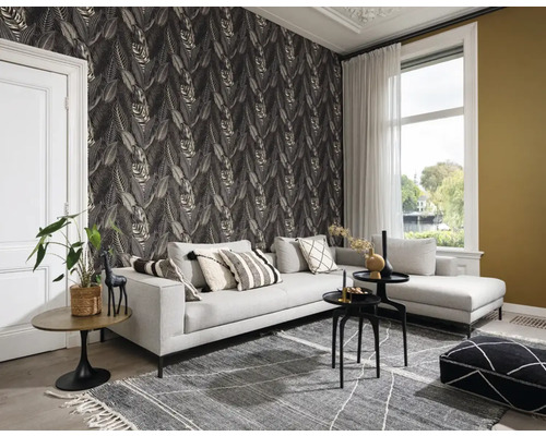 Wohnzimmer mit grauer Couch, gemusterter Tapete und Teppich