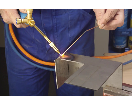 Ein Handwerker verwendet eine Lötlampe, um Metall zu bearbeiten.