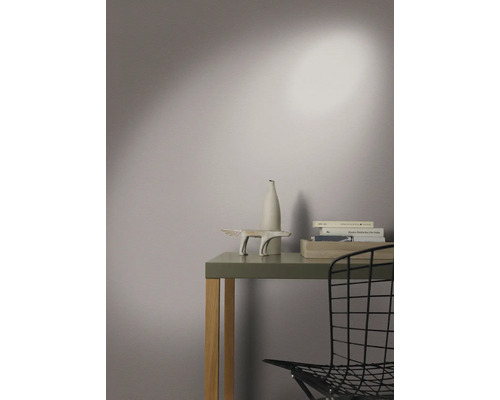 Dekoratives Arrangement auf einem Tisch mit Skulptur, Vase und Büchern in einem hellen Raum