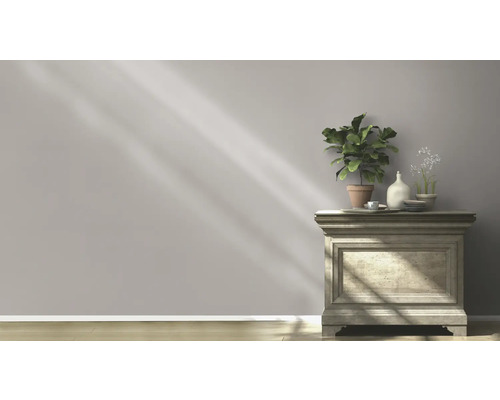 Dekoratives Sideboard mit Pflanzen und Dekorationselementen vor einer schlichten Wand