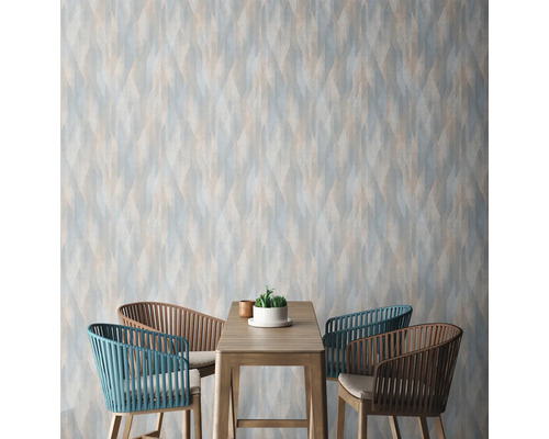 Raumansicht mit gemusterter Tapete, Tisch und Stühlen.