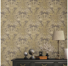 Nahaufnahme einer Wand mit floral gemusterter Tapete über einer schwarzen Kommode, die mit Dekorationsgegenständen und einer Lampe geschmückt ist.