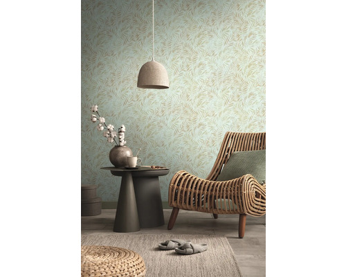 Wohnzimmer mit gemusterter Tapete, Rattansessel und Beistelltisch mit Dekoration