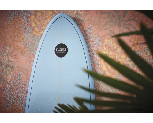 Surfbrett vor einer Wand mit Blumendekor