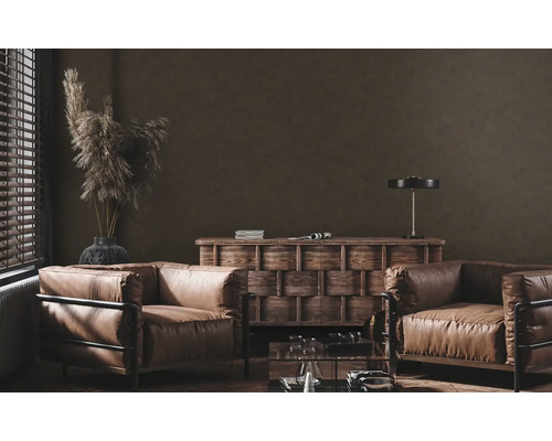 Wohnzimmer mit zwei Ledersesseln, Holzkommode und dekorativen Elementen.